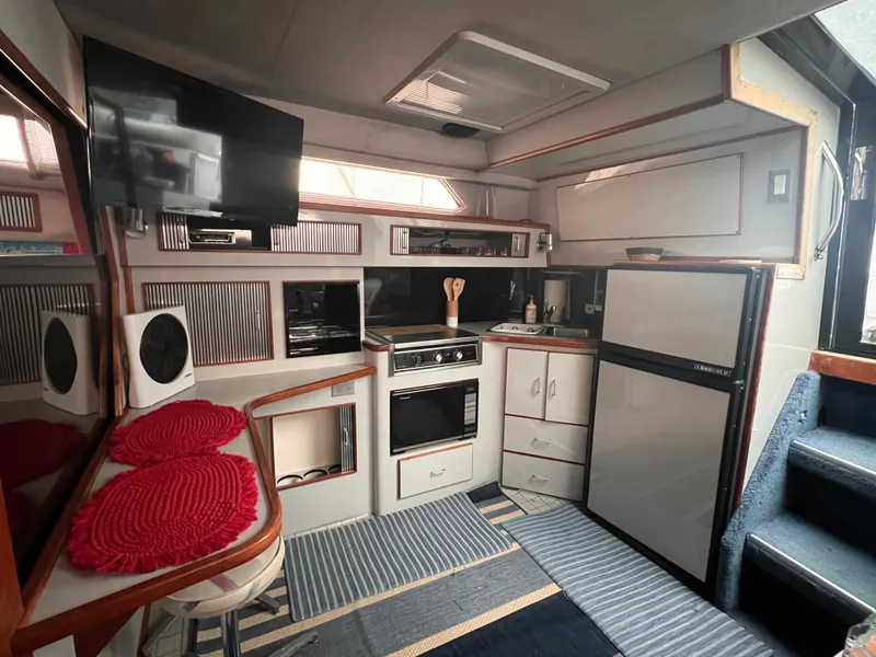 Slide: The Image of Interior of 1989 Sea Ray 390 Express Cruiser with modern kitchen amenities. - 25