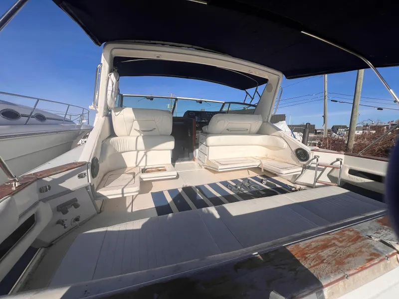 Slide: The Image of 1989 Sea Ray 390 Express Cruiser interior with striped flooring and waterfront view. - 4