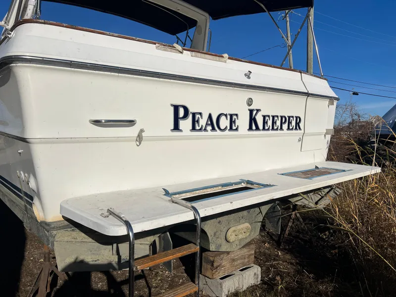 Slide: The Image of 1989 Sea Ray 390 Express Cruiser, white hull, docked outdoors under clear blue sky. - 41
