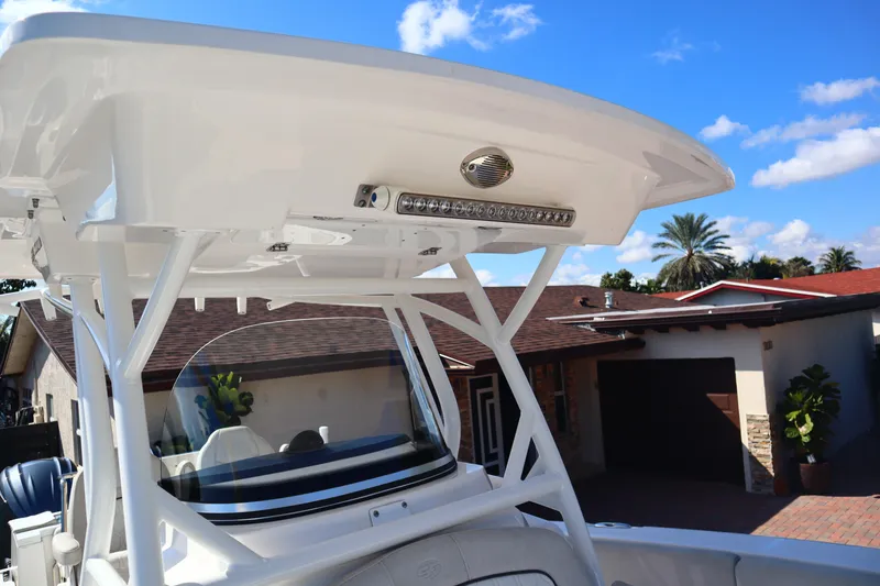 Slide: The Image of 2022 Sea Fox 288 Commander boat with T-top and LED lights, parked near a house. - 32