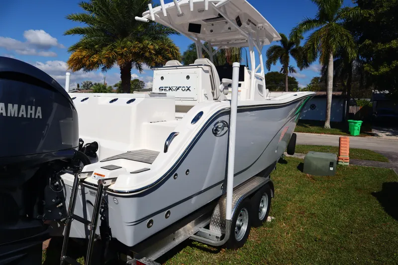 Slide: The Image of 2022 Sea Fox 288 Commander boat on trailer, parked outdoors with palm trees in background. - 35