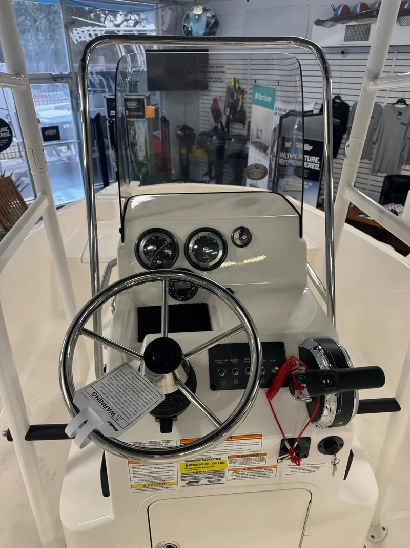 Slide: The Image of 2025 Bayliner Trophy T18 boat dashboard with steering wheel and controls. - 4