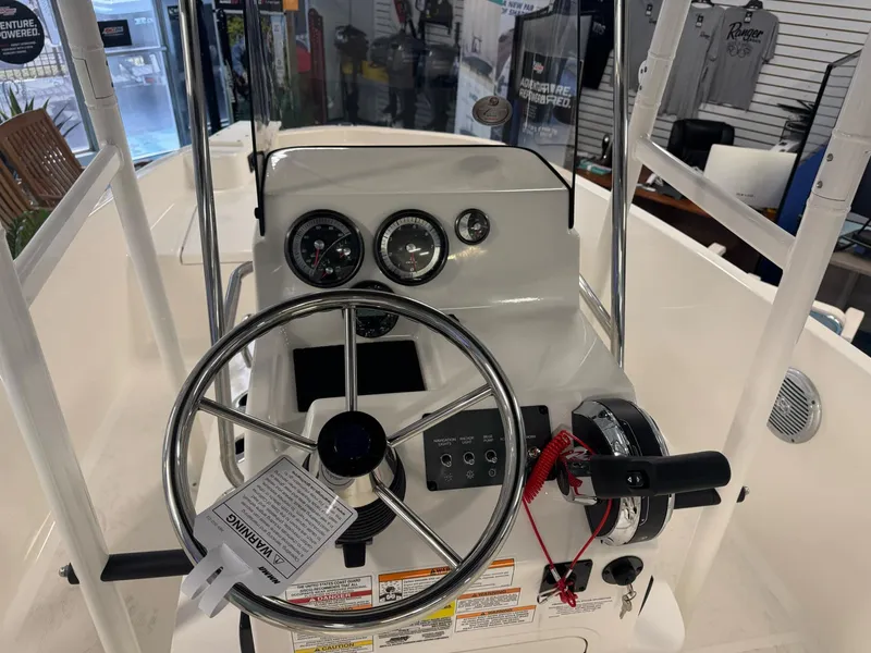Slide: The Image of 2025 Bayliner Trophy T18 boat dashboard with steering wheel and control panel. - 5