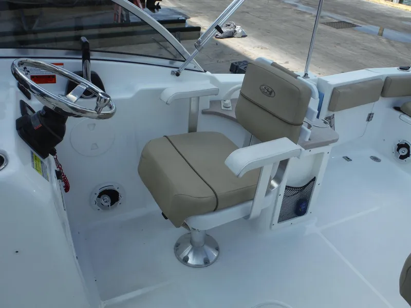 Slide: The Image of 2016 Sea Hunt Escape 235 SE boat interior with steering wheel and captain's chair. - 14