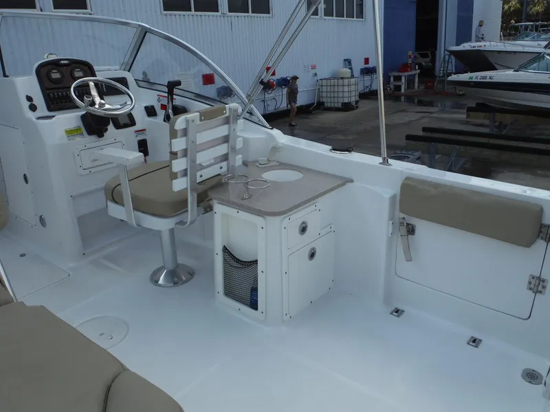 Slide: The Image of 2016 Sea Hunt Escape 235 SE boat interior with helm, seating, and storage. - 16
