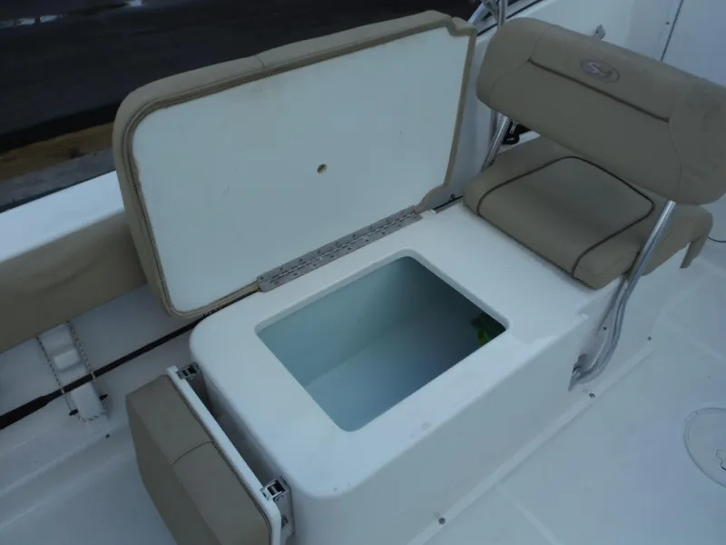 Slide: The Image of 2016 Sea Hunt Escape 235 SE boat with open storage compartment and cushioned seating. - 27