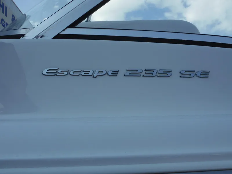 Slide: The Image of 2016 Sea Hunt Escape 235 SE boat model nameplate on white hull. - 32
