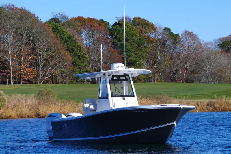 Slide: The Image of 2023 Regulator 28 boat on a serene lake with autumn trees in the background. - 10