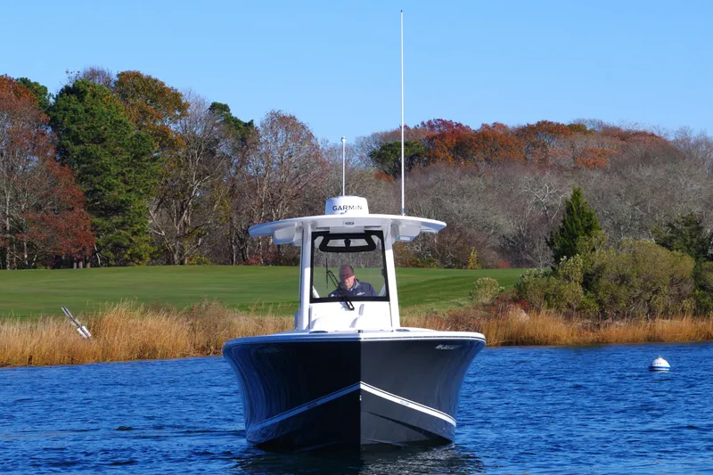 Slide: The Image of 2023 Regulator 28 boat cruising on a scenic lake with autumn foliage. - 11