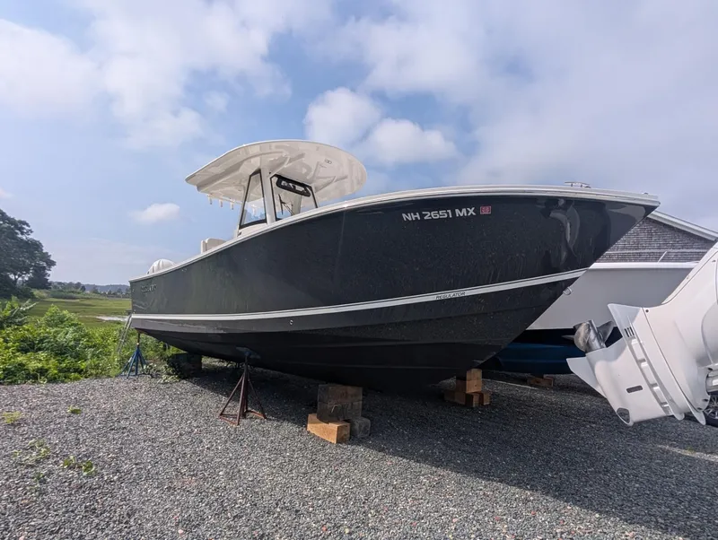 Slide: The Image of 2023 Regulator 28 boat on gravel, under a partly cloudy sky. - 13