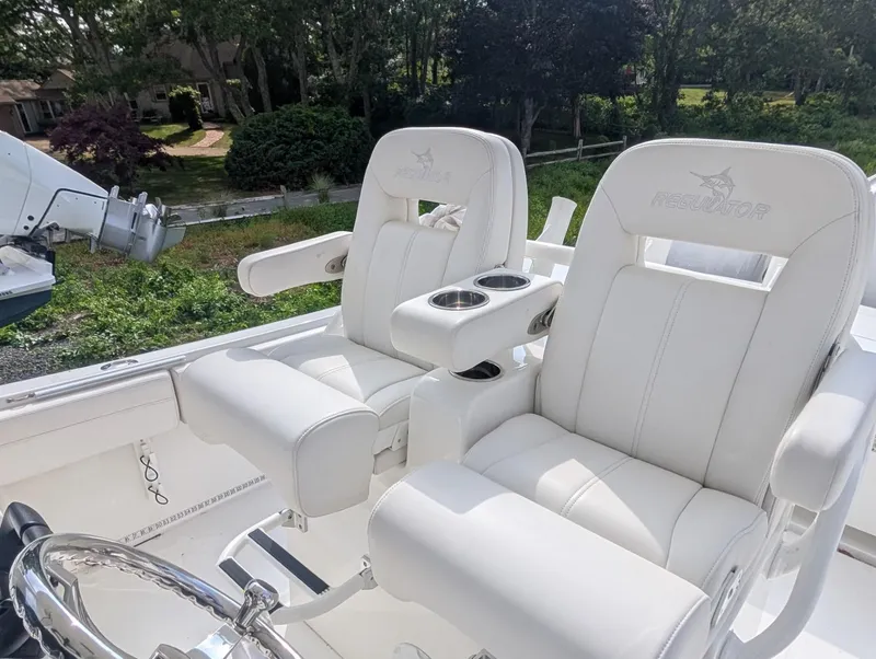 Slide: The Image of 2023 Regulator 28 boat with luxurious white seating and cup holders. - 14