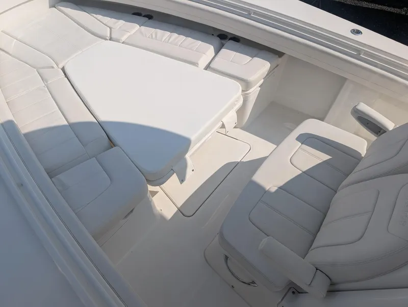 Slide: The Image of 2023 Regulator 28 boat interior with white cushioned seating and table. - 18