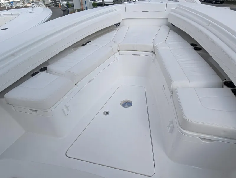 Slide: The Image of 2023 Regulator 28 boat interior with white cushioned seating and storage compartments. - 19
