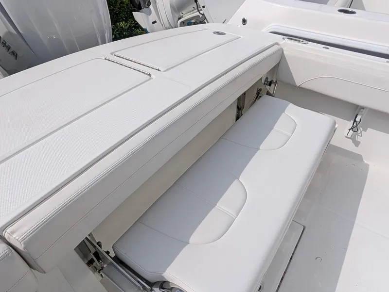 Slide: The Image of 2023 Regulator 28 boat interior with white cushioned seating and storage compartments. - 21