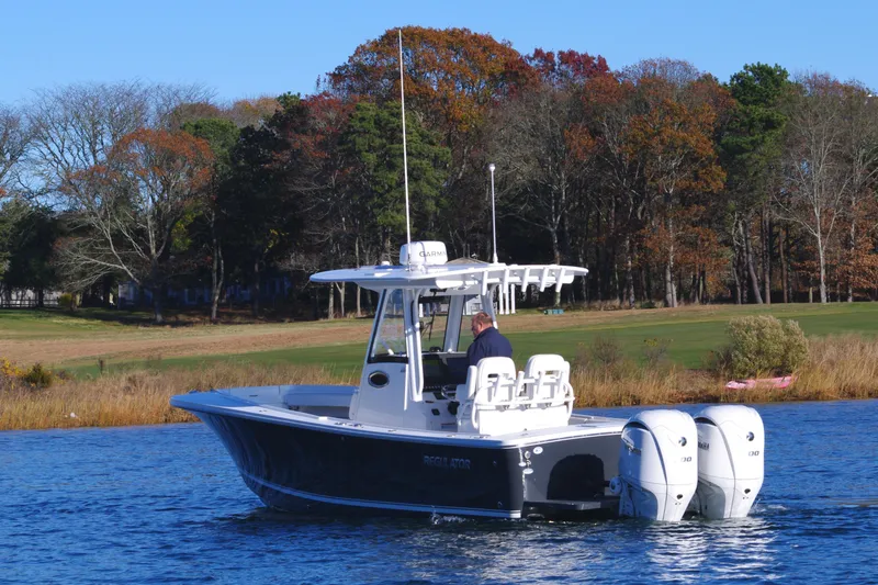 Slide: The Image of 2023 Regulator 28 boat on a lake with autumn trees in the background. - 3