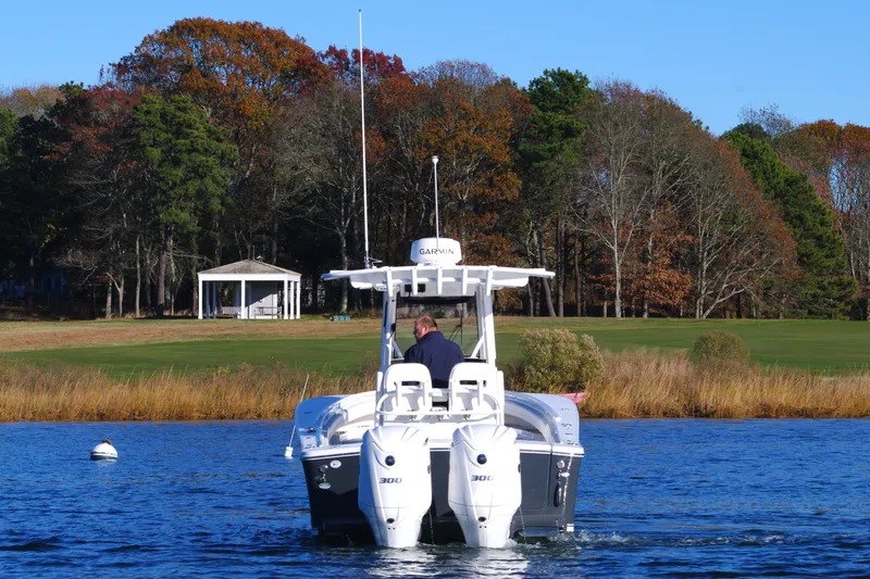 Slide: The Image of 2023 Regulator 28 boat cruising on a lake with autumn trees in the background. - 4