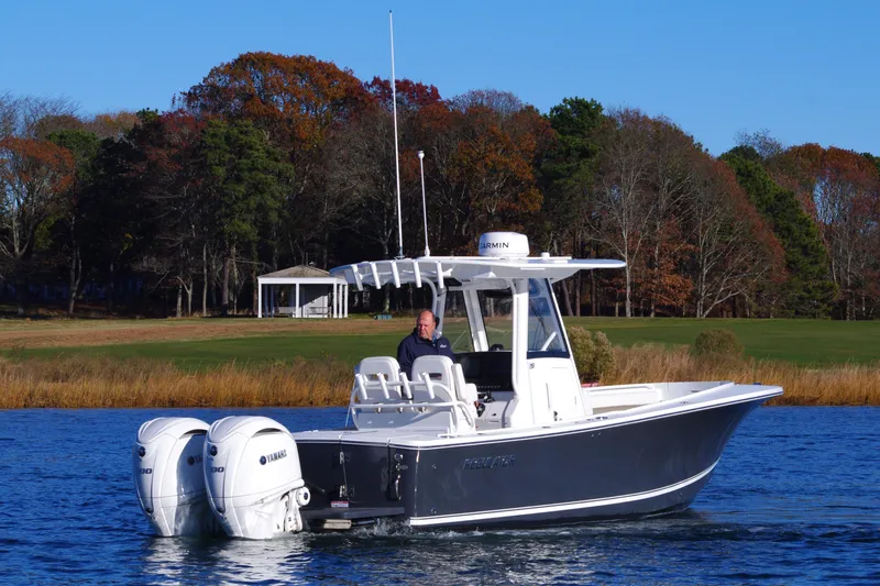 Slide: The Image of 2023 Regulator 28 boat with dual Yamaha engines on a calm lake. - 6