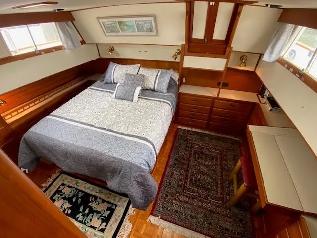 Slide: The Image of Cozy bedroom in 1993 Grand Banks Classic yacht with elegant wood finish and decorative rugs. - 10