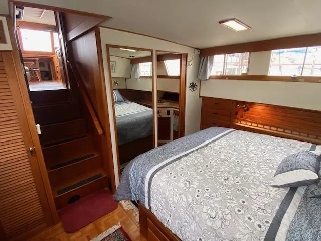 Slide: The Image of Cozy bedroom in 1993 Grand Banks Classic yacht with wooden interior and floral bedding. - 11