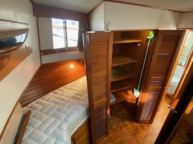 Slide: The Image of 1993 Grand Banks Classic cabin interior with bed, wooden paneling, and open closet. - 20