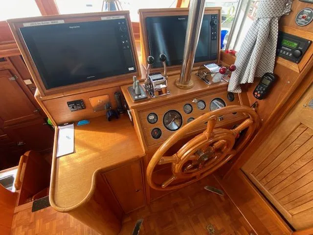 Slide: The Image of 1993 Grand Banks Classic helm with wooden wheel, dual monitors, and navigation controls. - 22