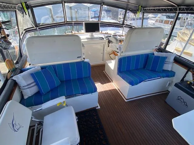 Slide: The Image of 1993 Grand Banks Classic yacht interior with blue-striped seating and wooden flooring. - 26