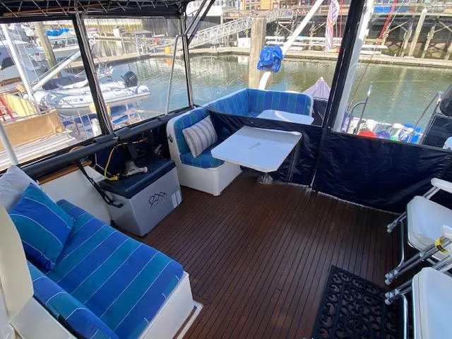 Slide: The Image of 1993 Grand Banks Classic boat interior with blue seating, table, and marina view. - 27