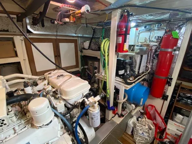 Slide: The Image of Engine room of a 1993 Grand Banks Classic boat, featuring machinery and safety equipment. - 42