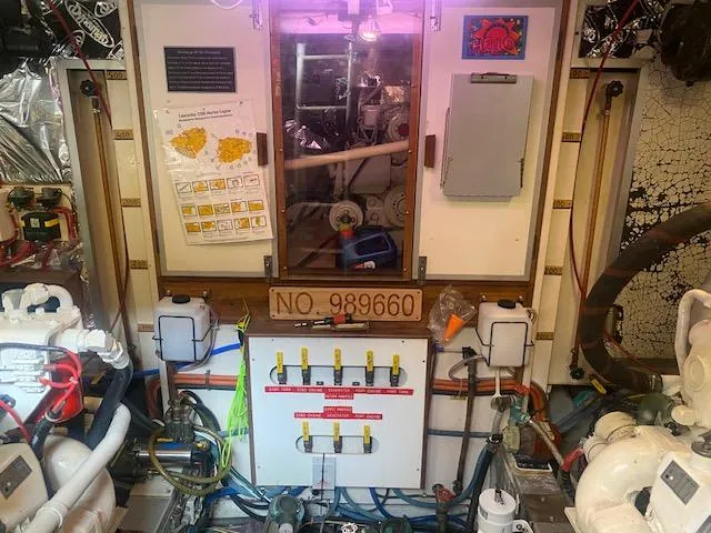 Slide: The Image of Engine room of a 1993 Grand Banks Classic boat, featuring control panels and equipment. - 46