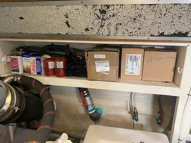 Slide: The Image of Storage shelf in a 1993 Grand Banks Classic boat engine room with various maintenance supplies. - 47