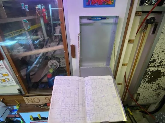 Slide: The Image of Logbook on a 1993 Grand Banks Classic boat, engine room in background. - 49