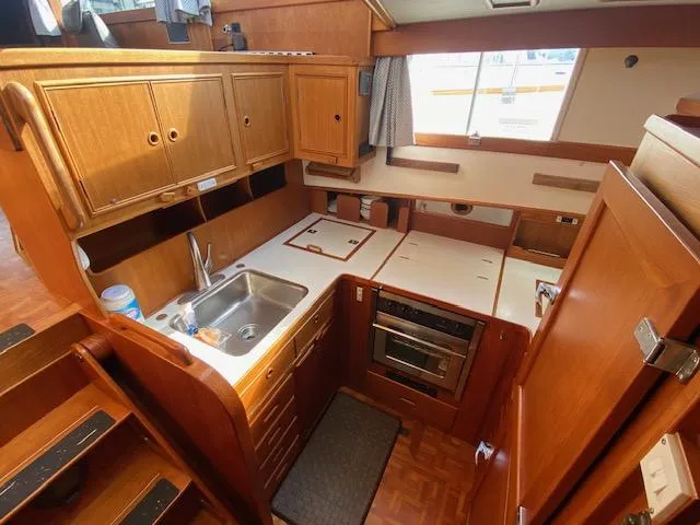 Slide: The Image of 1993 Grand Banks Classic yacht kitchen with wooden cabinetry, sink, and oven. - 7
