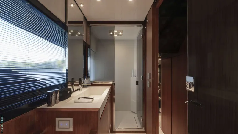 Slide: The Image of Interior view of 2024 Riva 66' Ribelle yacht, featuring elegant wooden stairs and seating area. - 16