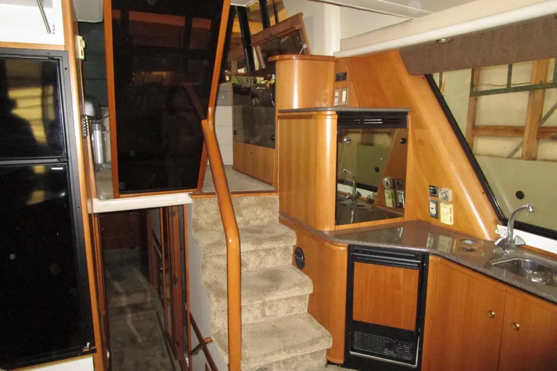 Slide: The Image of 1999 Bayliner 4788 Pilot House Motoryacht interior with stairs and kitchenette. - 18