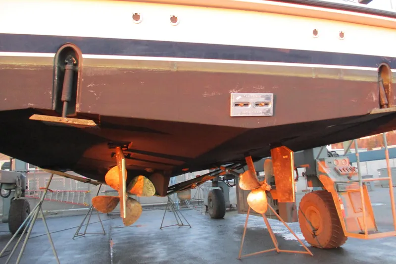 Slide: The Image of 1999 Bayliner 4788 Pilot House Motoryacht under maintenance, showcasing propellers and hull structure. - 2