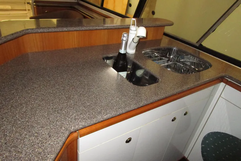 Slide: The Image of 1999 Bayliner 4788 Pilot House Motoryacht kitchen with sink, faucet, and countertop. - 22
