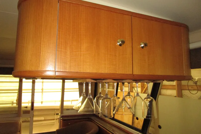Slide: The Image of Wooden cabinet with hanging glassware in a 1999 Bayliner 4788 Pilot House Motoryacht. - 23