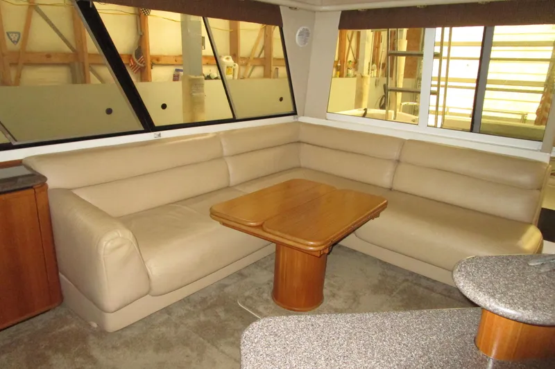 Slide: The Image of Luxurious interior of 1999 Bayliner 4788 Pilot House Motoryacht with beige seating and wooden table. - 24