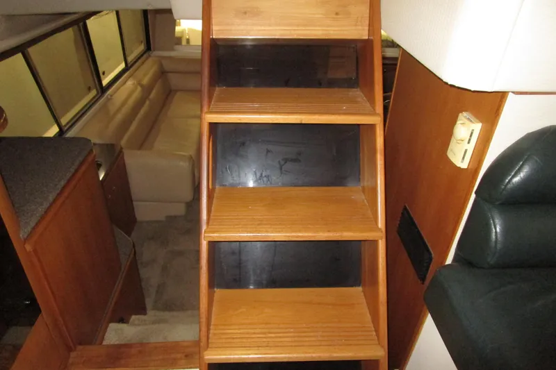 Slide: The Image of Interior of 1999 Bayliner 4788 Pilot House Motoryacht with wooden stairs and seating area. - 28