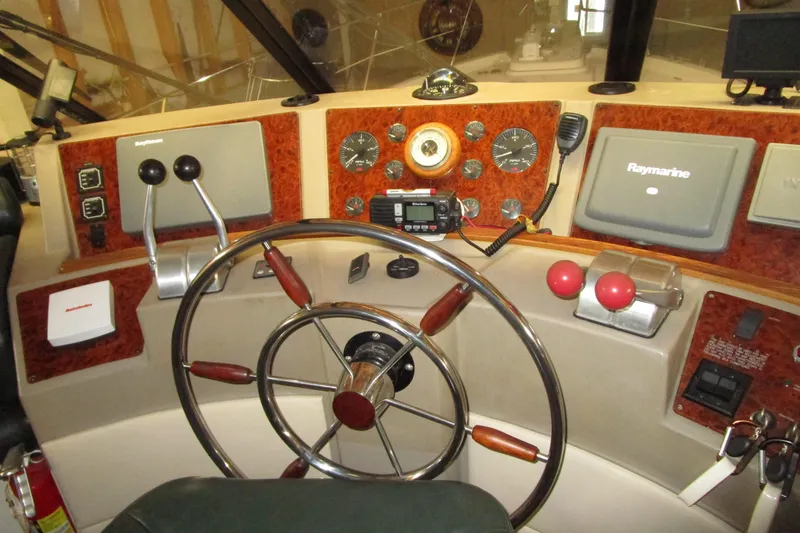 Slide: The Image of 1999 Bayliner 4788 Pilot House Motoryacht helm with steering wheel and navigation controls. - 30