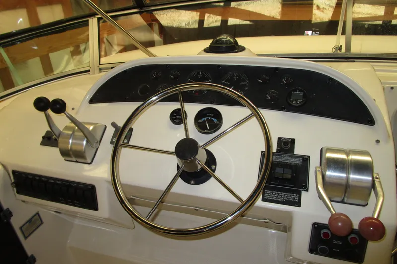 Slide: The Image of 1999 Bayliner 4788 Pilot House Motoryacht helm with steering wheel and control panel. - 32