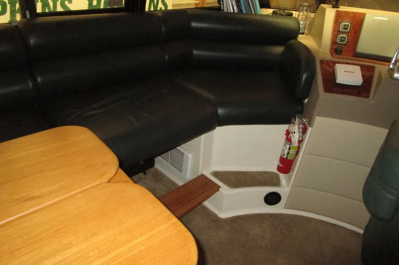 Slide: The Image of 1999 Bayliner 4788 Pilot House Motoryacht interior with black seating and wooden table. - 40