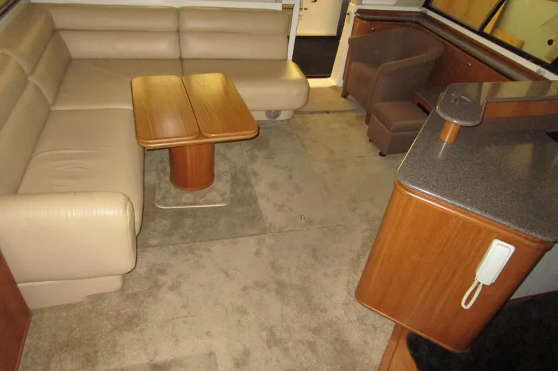 Slide: The Image of Interior of 1999 Bayliner 4788 Pilot House Motoryacht with beige seating and wooden accents. - 45