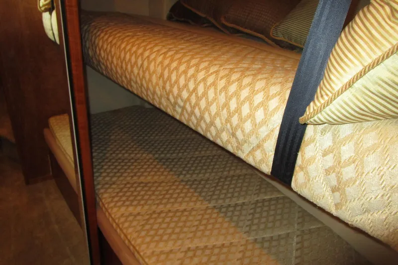 Slide: The Image of Bunk beds in 1999 Bayliner 4788 Pilot House Motoryacht cabin, featuring patterned bedding. - 53