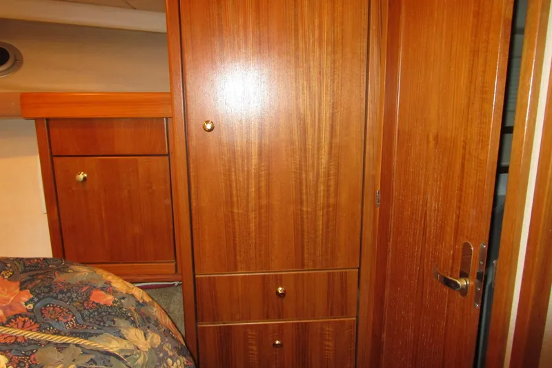 Slide: The Image of 1999 Bayliner 4788 Pilot House Motoryacht interior with wooden cabinetry and floral bedding. - 55