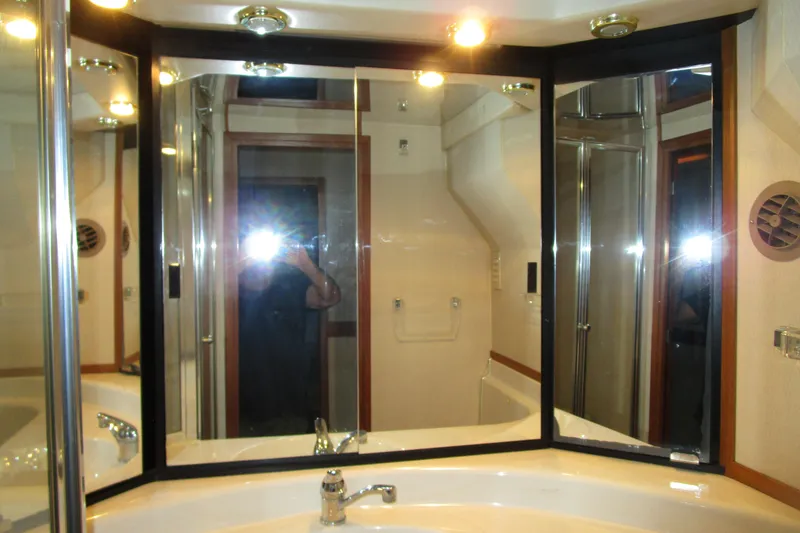 Slide: The Image of Bathroom vanity with mirrors and lighting in 1999 Bayliner 4788 Pilot House Motoryacht. - 57