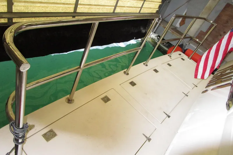 Slide: The Image of 1999 Bayliner 4788 Pilot House Motoryacht deck with railing and American flag. - 6