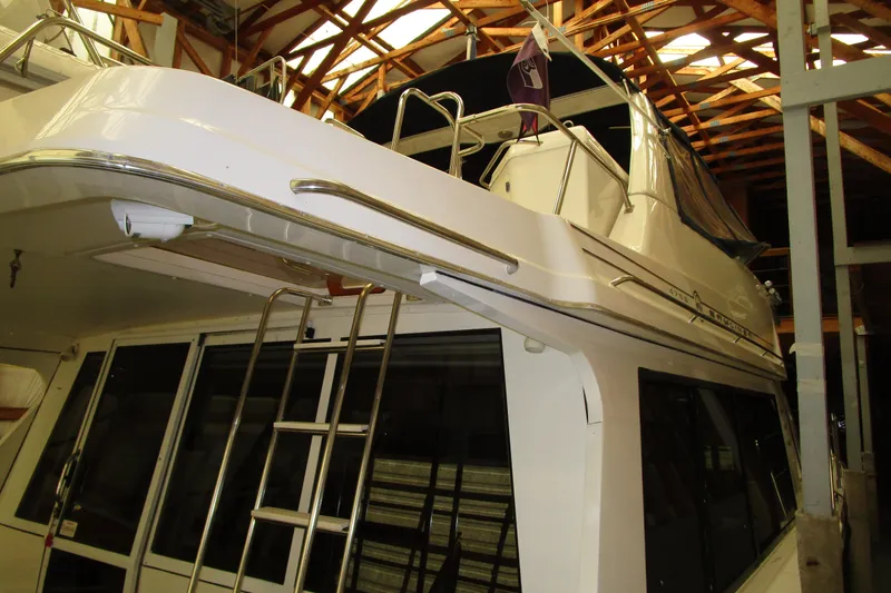 Slide: The Image of 1999 Bayliner 4788 Pilot House Motoryacht in storage, showcasing upper deck and ladder. - 68