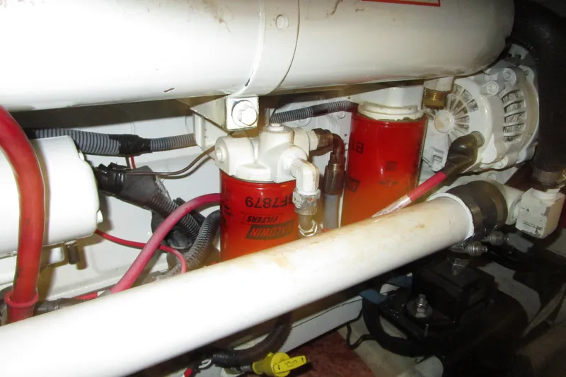 Slide: The Image of Engine compartment of a 1999 Bayliner 4788 Pilot House Motoryacht, showing filters and wiring. - 77