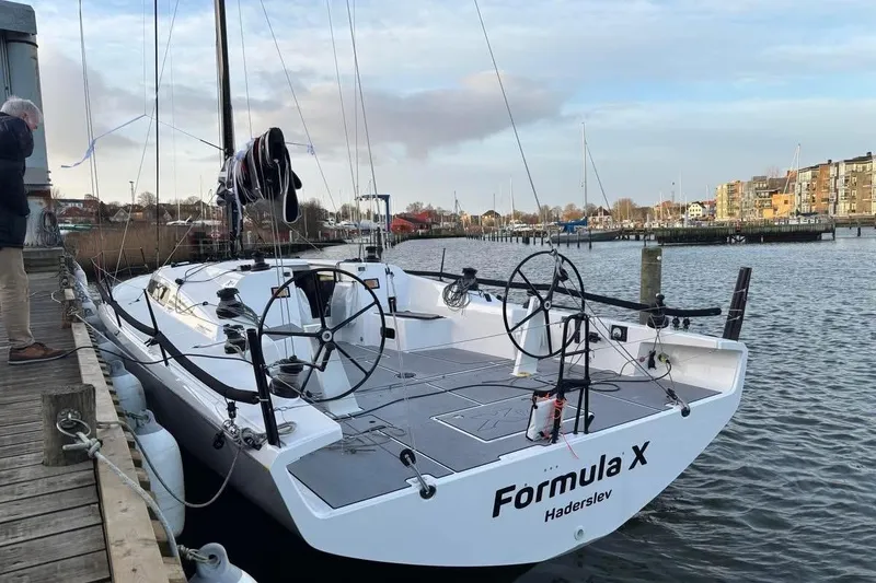 Slide: The Image of 2025 X-Yachts XR 41 sailboat docked, featuring dual steering wheels and sleek design. - 9